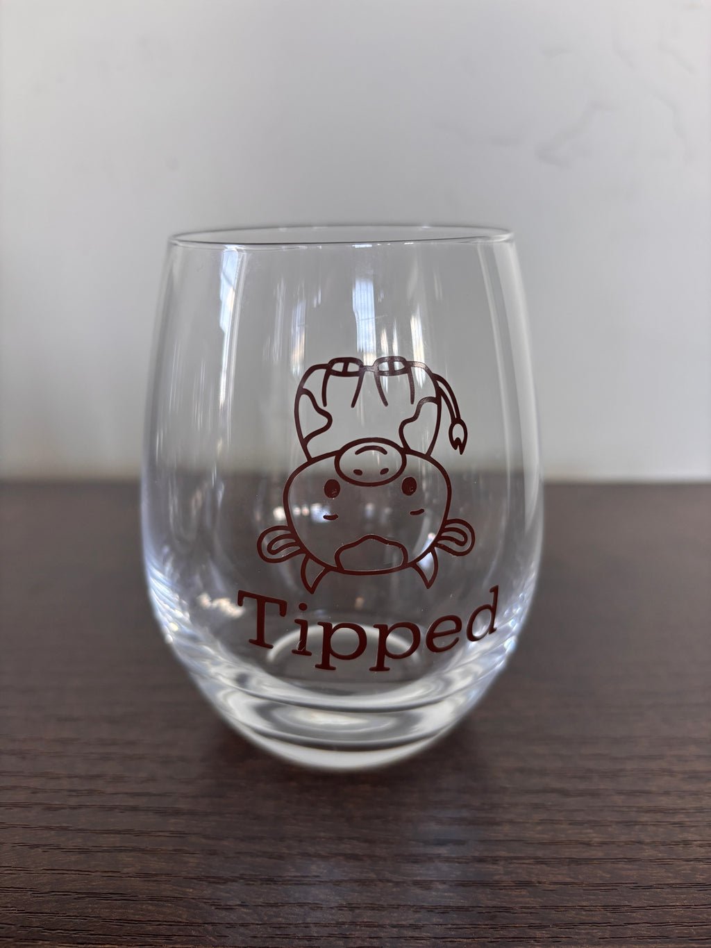 Tipsy or tipped stemless wine glass